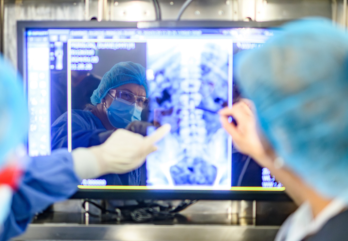 a person in scrubs looking at an x-ray
