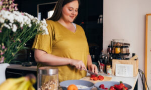 a woman cutting tomatoes in a kitchen