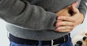a close-up of a man's hands folded on stomach