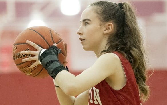 girl playing basketball with wrist brace