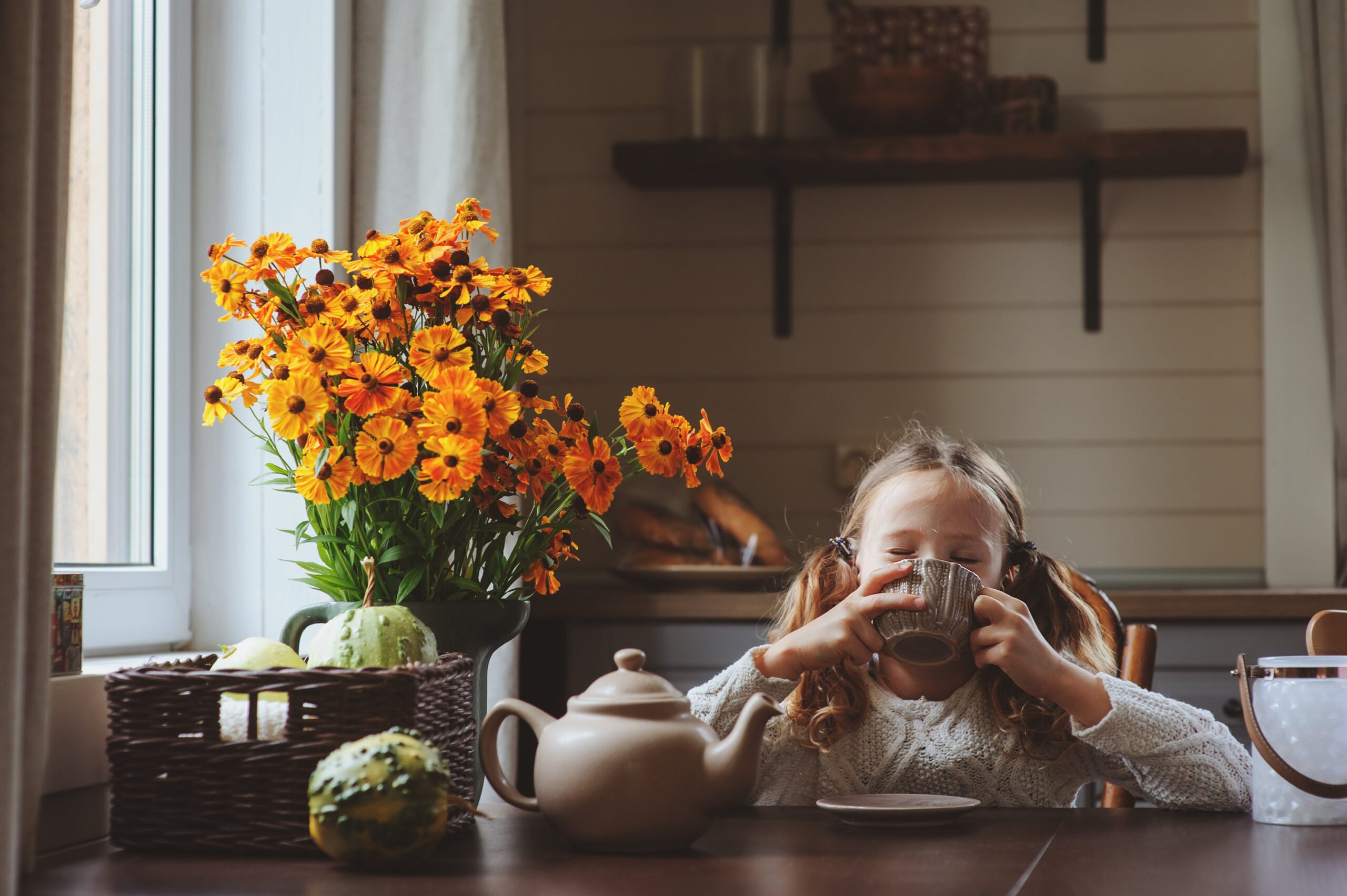 Young girl drinking tea at the table