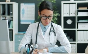 female provider sitting at a desk looking down writing