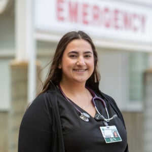 Smiling nurse outside emergency department.