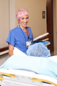 Nurse smiling while assisting patient.