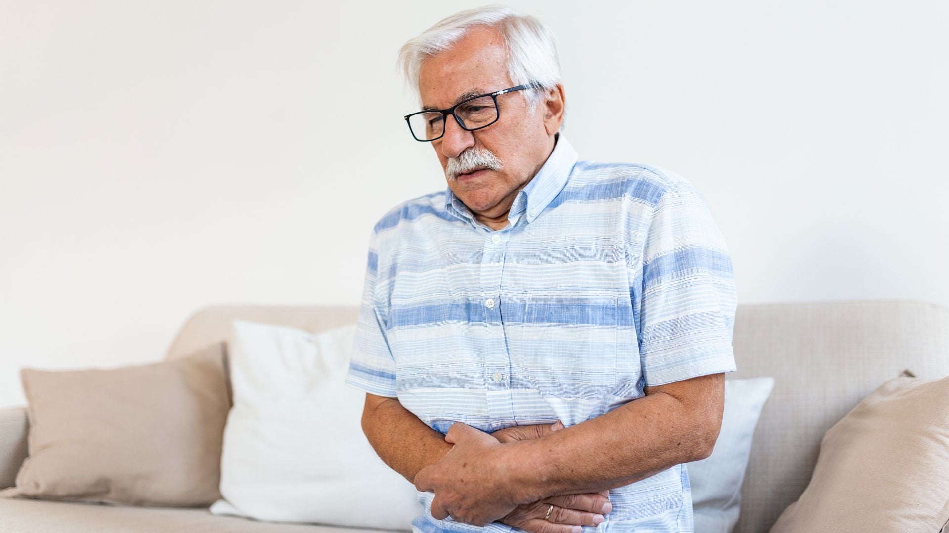 old man holding stomach from pain